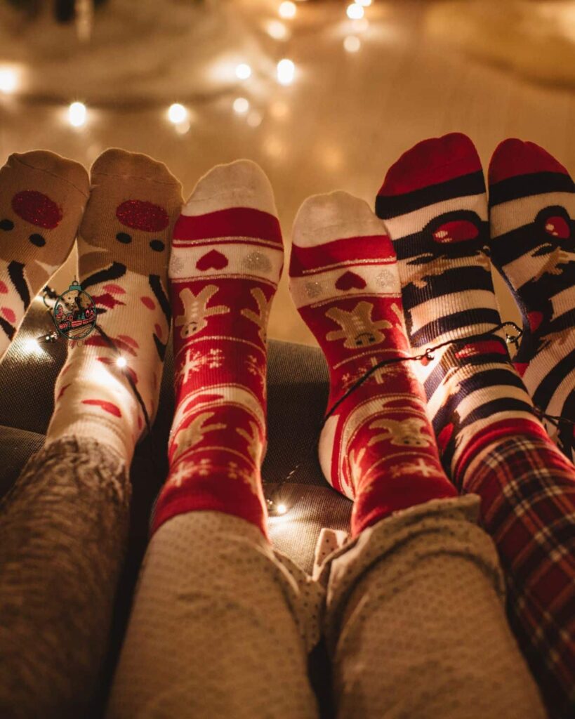 Legs and feet that have Christmas pajamas and Christmas socks on.