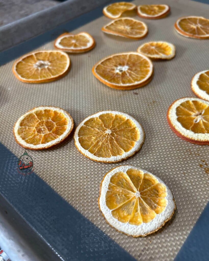 Dried orange slices on a sheet pan after being dried in the oven.