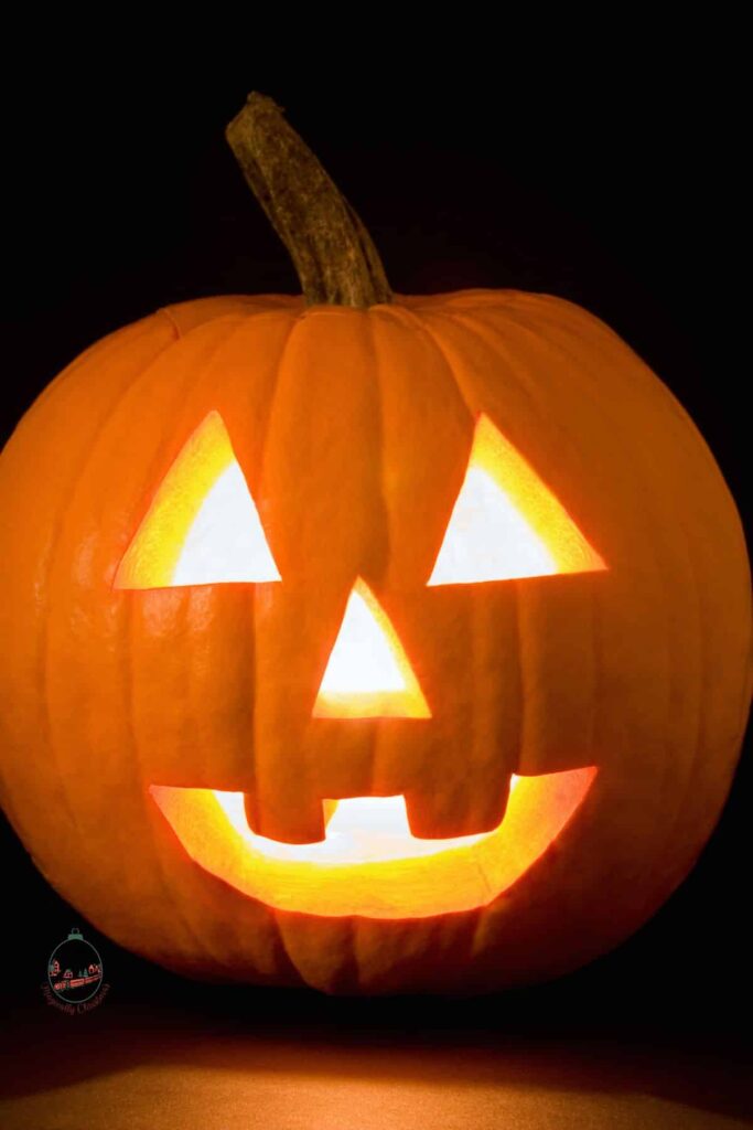 A happy faced carved pumpkin that is ready for the Halloween season.