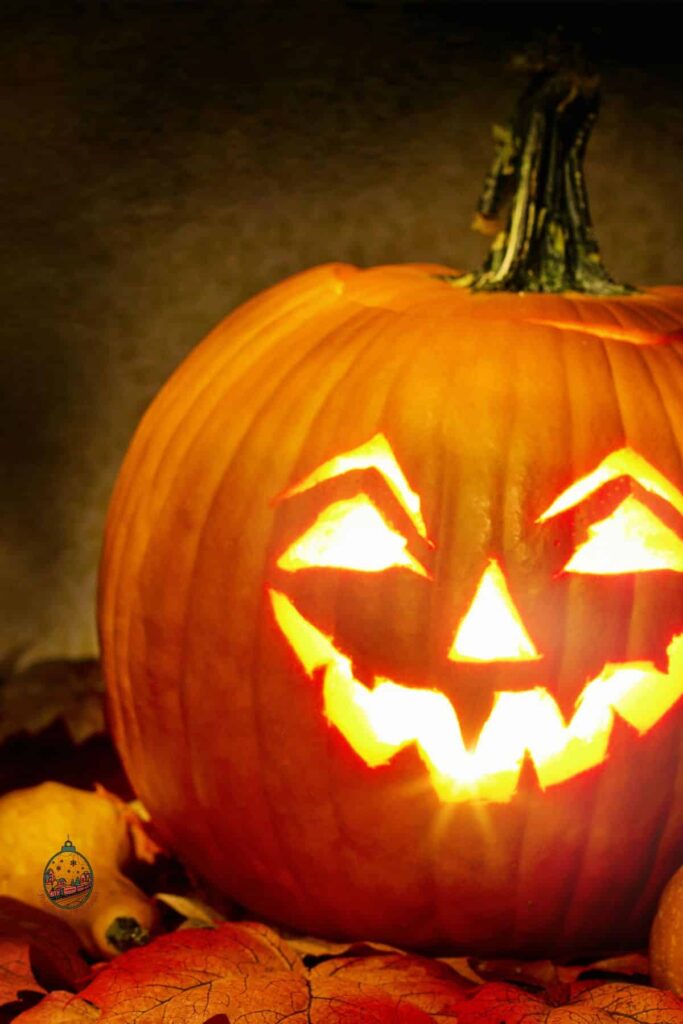 One single pumpkin that has a happy carved face on it that is lit up and glowing.