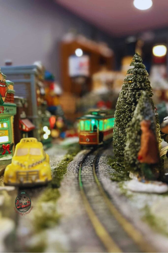 A trolley on the train tracks of Frosty Falls Christmas village.