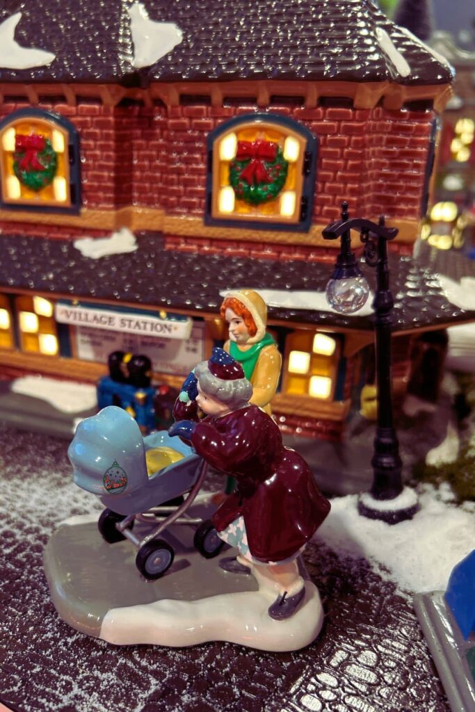 A department 56 figure of What An Adorable Baby that is on the Christmas Village.